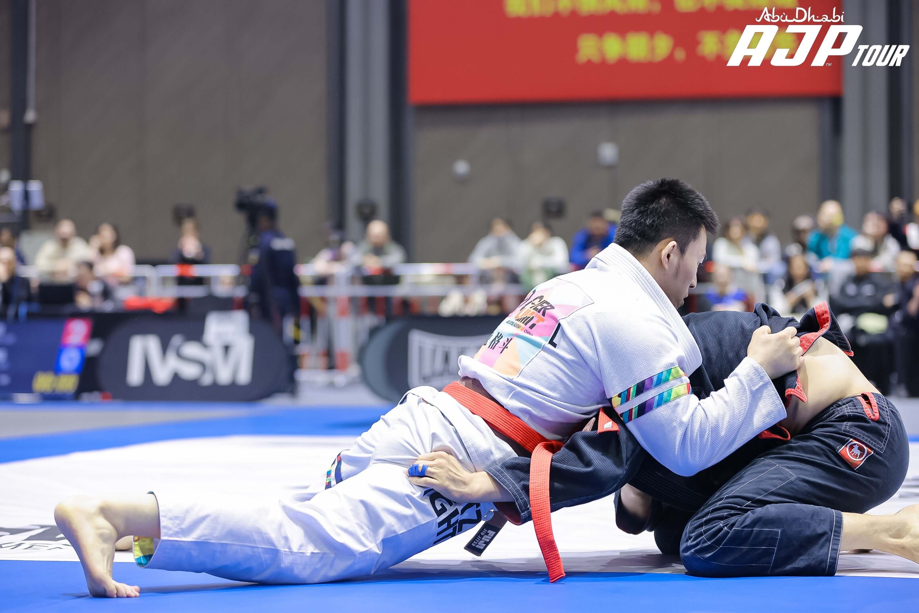 Competitors showcasing skills in a BJJ competition, demonstrating IBJJF Gi requirements.