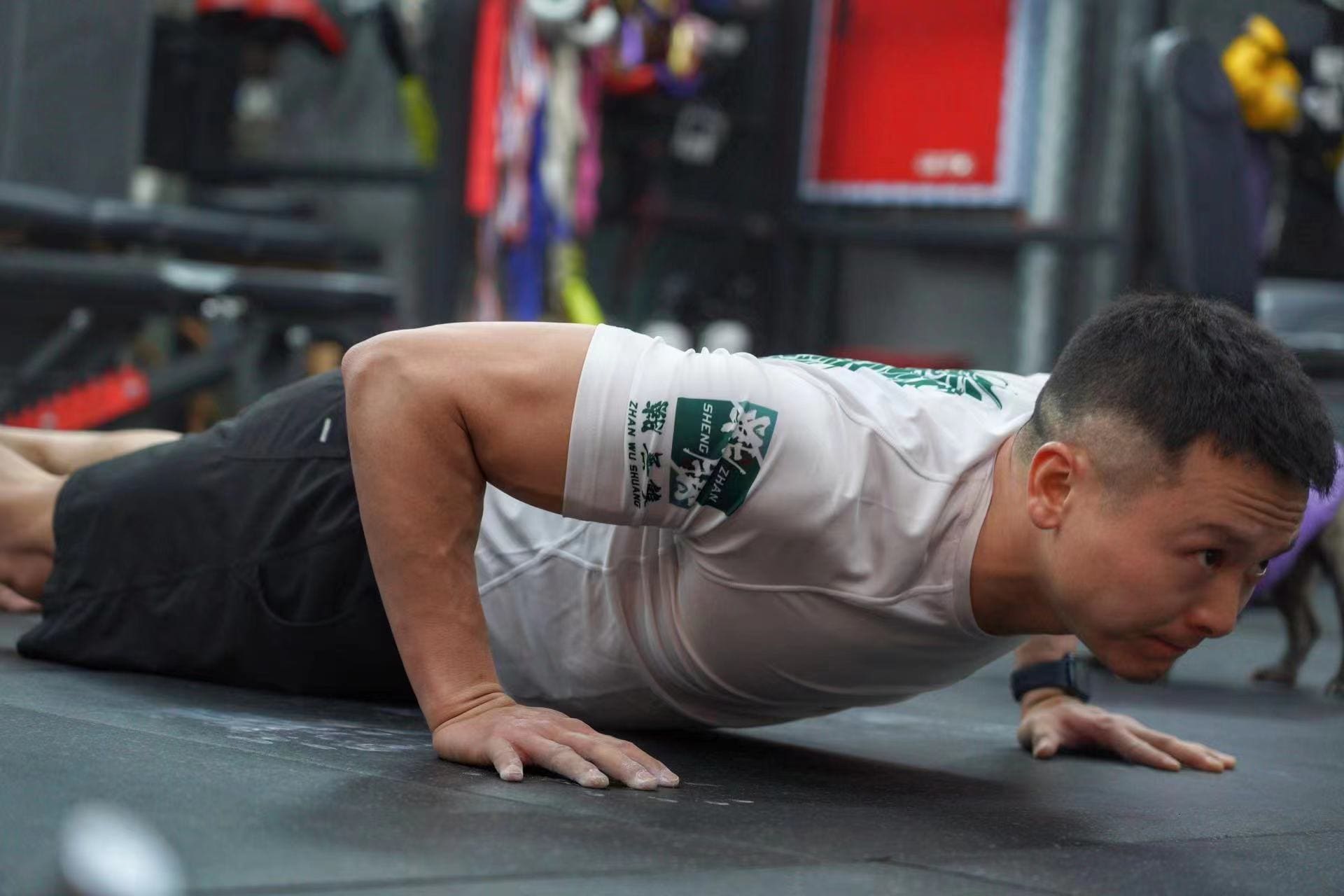 Athlete performing push-ups in Dragon Year Limited Edition Rash Guard during BJJ training session in the gym.