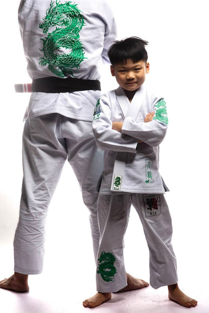 Child in ZHAN Year of the Dragon Limited Edition BJJ Gi with green dragon embroidery, standing confidently next to an adult in matching gear.