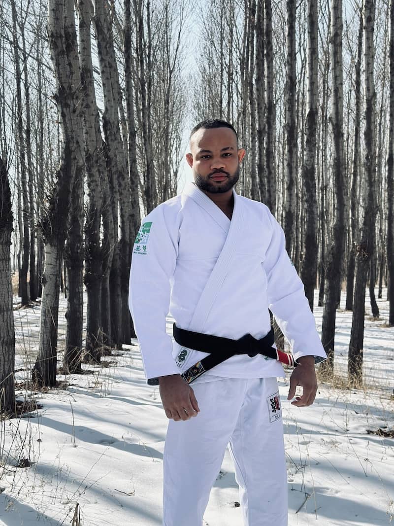 BJJ practitioner wearing ZHAN Year of the Dragon Limited Edition Gi stands confidently in a snowy forest background