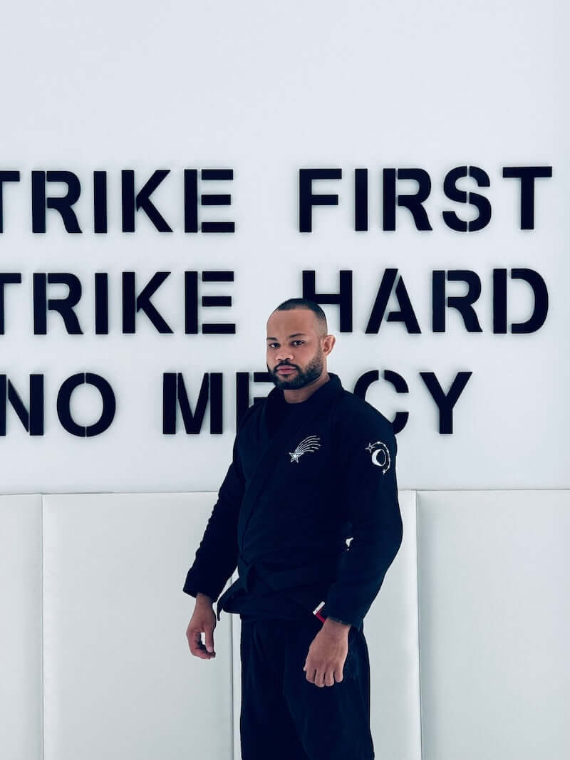 Practicing martial arts in BLITZ Sun & Moon Brazilian Jiu-Jitsu Gi against a motivational wall.
