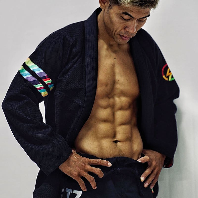 Model in a black rainbow pattern BJJ gi looking down