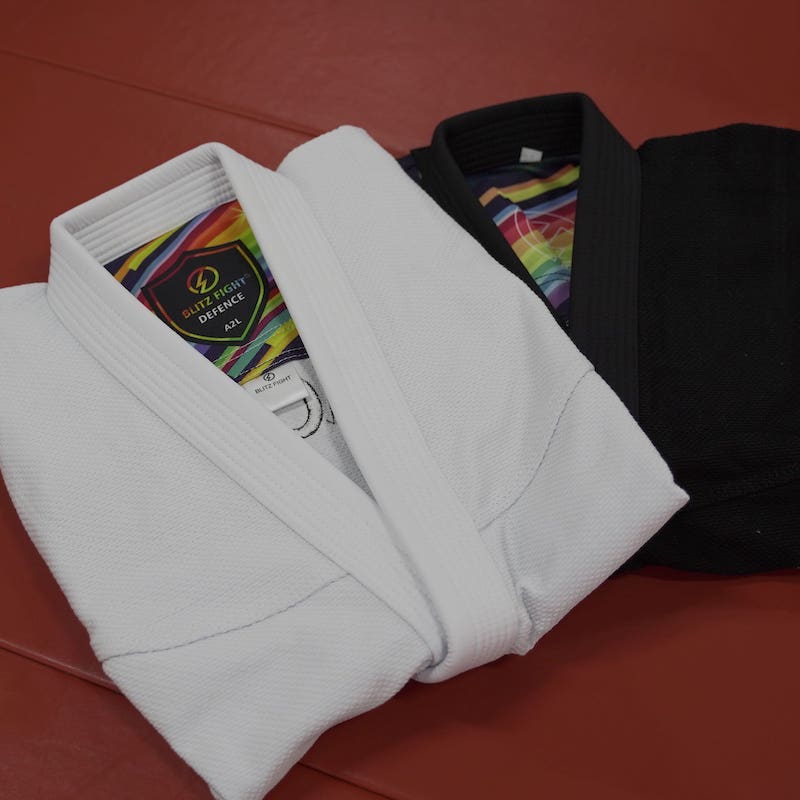 Folded tops of black and white rainbow pattern Brazilian Jiu-Jitsu gis placed together