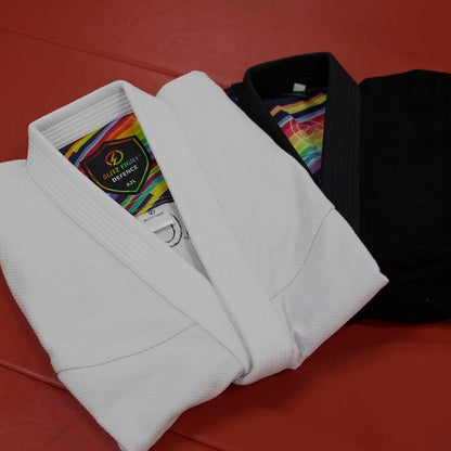 Folded tops of black and white rainbow pattern Brazilian Jiu-Jitsu gis placed together