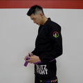Conjunto de Jiu-Jitsu Rainbow da Série BLITZ DEFENSE: Kimono resistente e estiloso, usado por um praticante com faixa roxa.