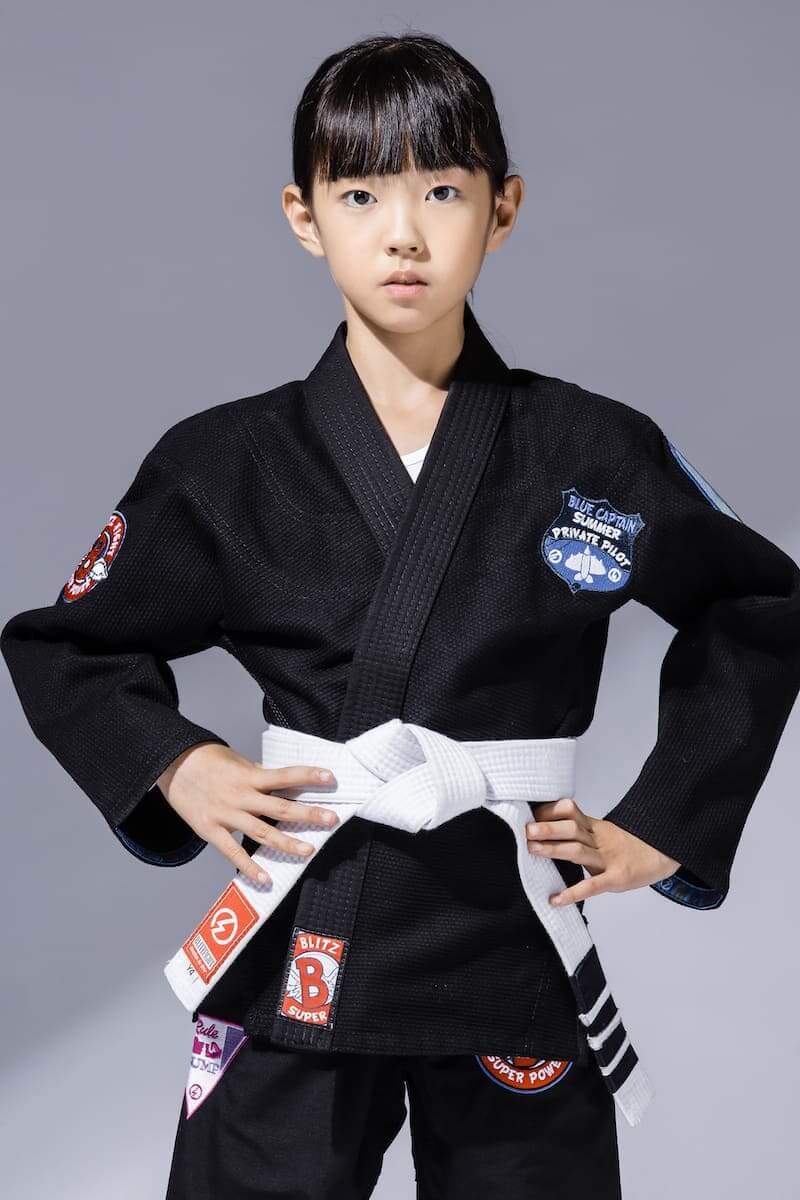 BLITZ Kids Super Power BJJ Gi worn by a young girl, showcasing its comfortable and durable design for training.