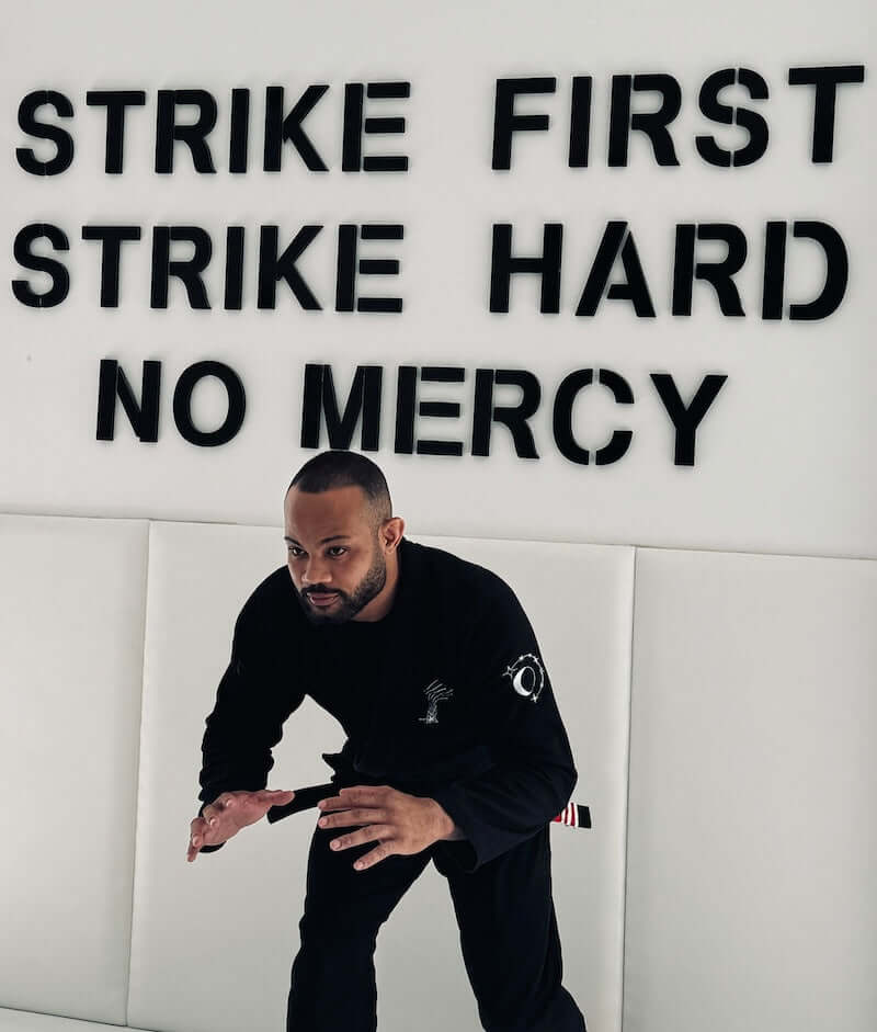 Athlete wearing BLITZ Sun & Moon Brazilian Jiu-Jitsu Gi with motivational text in background, preparing for action.