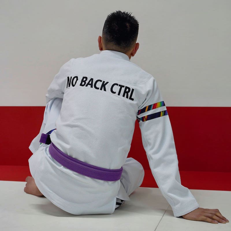 Back view of a model wearing a white rainbow pattern BJJ gi